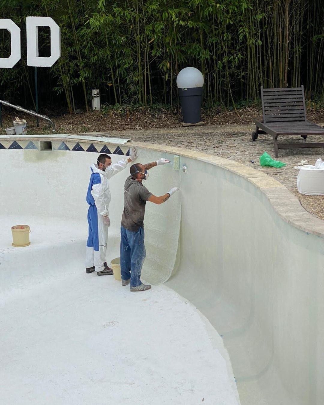 Equipa a aplicar o revestimento numa piscina