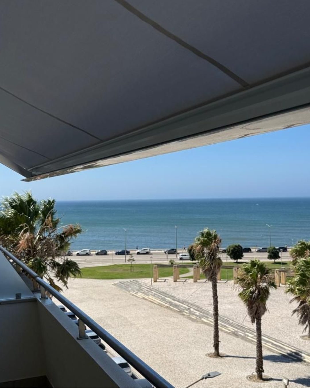 Toldo em varanda com vista para o mar e palmeiras