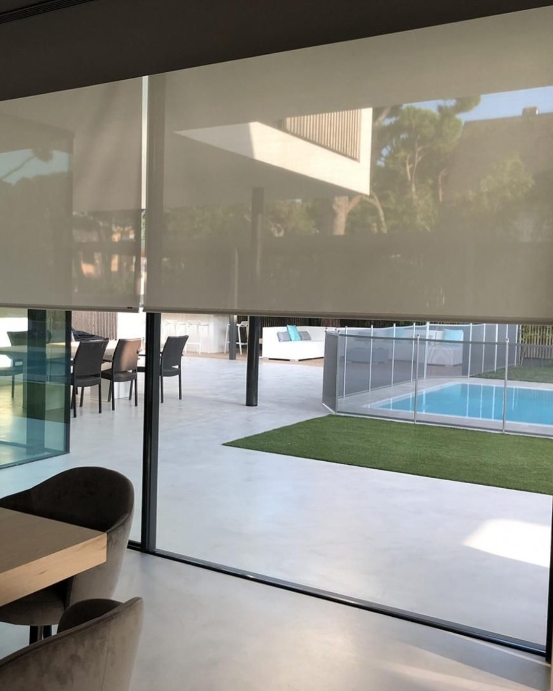 Estore screen numa sala com vista para a piscina
