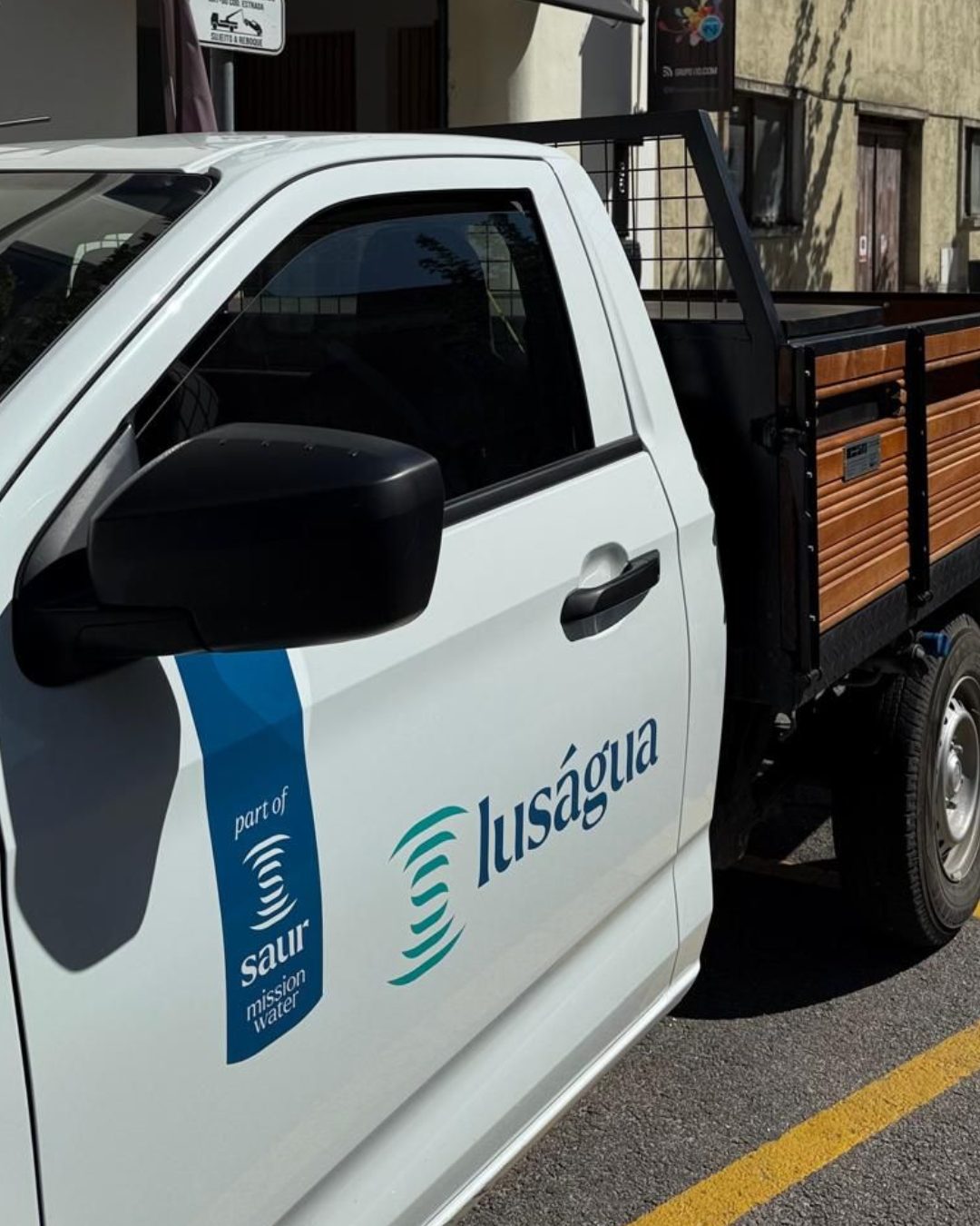 Carrinha branca decorada com a marca Luságua