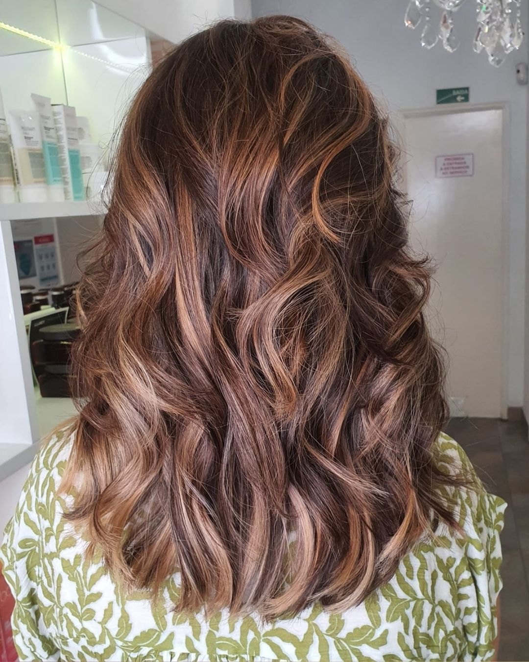 Cabelo castanho com madeixas caramelo, em ondas